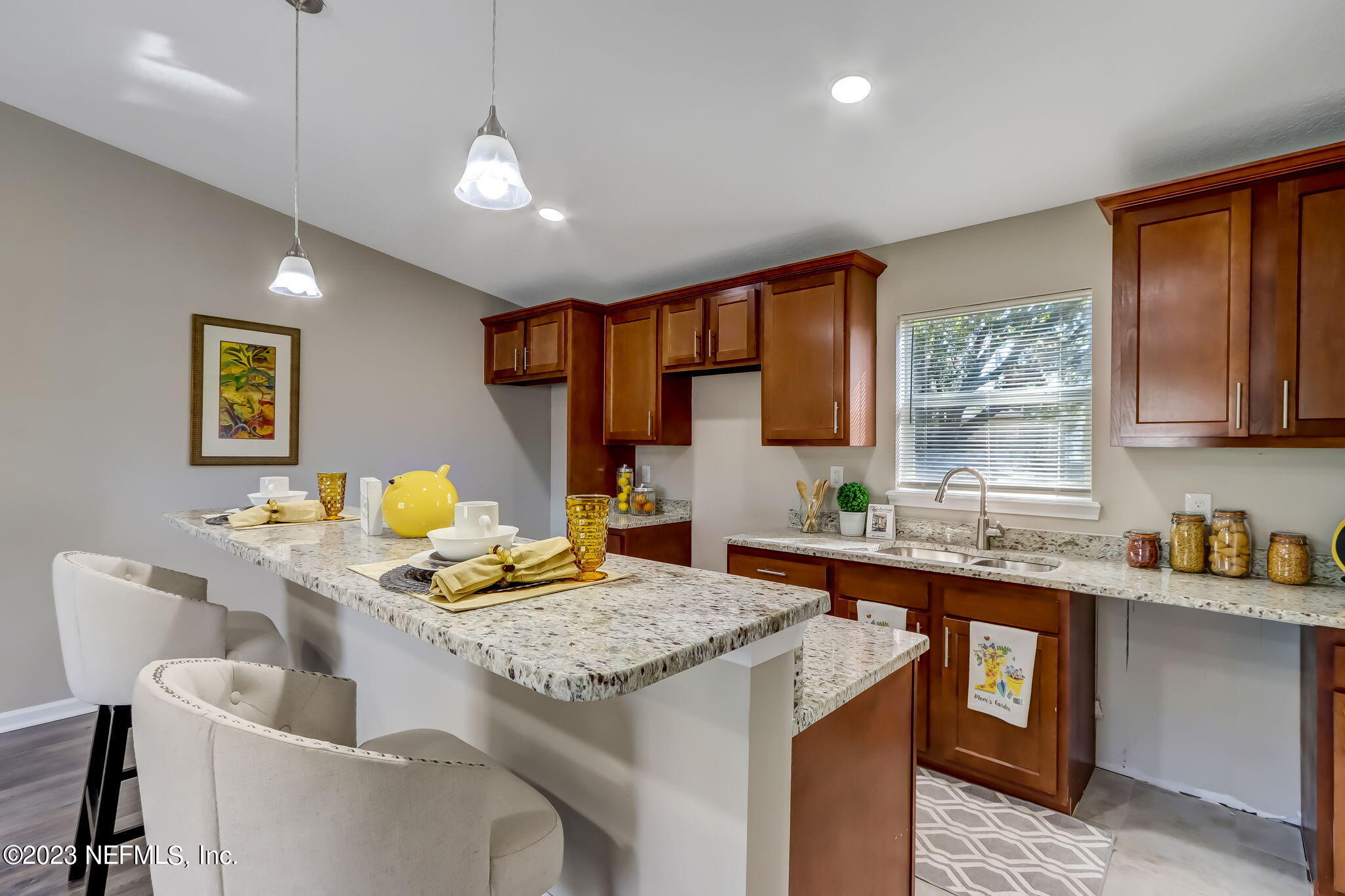 8545 Laurens Road Jacksonville, FL 32208 - Photo 8 of 29 a kitchen with a stove a sink a dining table and chairs