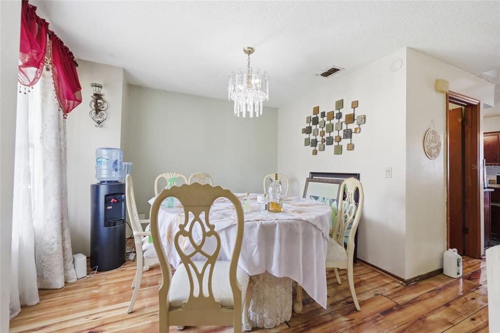 3027 Queens Gate Road Orlando, FL 32818 - Photo 21 of 34 a view of a dining room with furniture window and wooden floor
