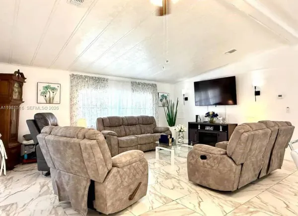 a living room with furniture a flat screen tv and a window