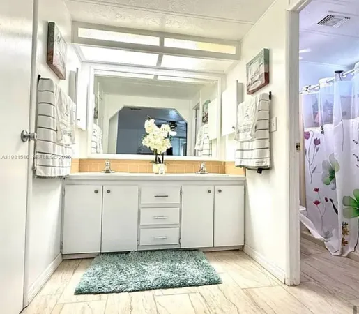 a spacious bathroom with a granite countertop sink a mirror and a shower