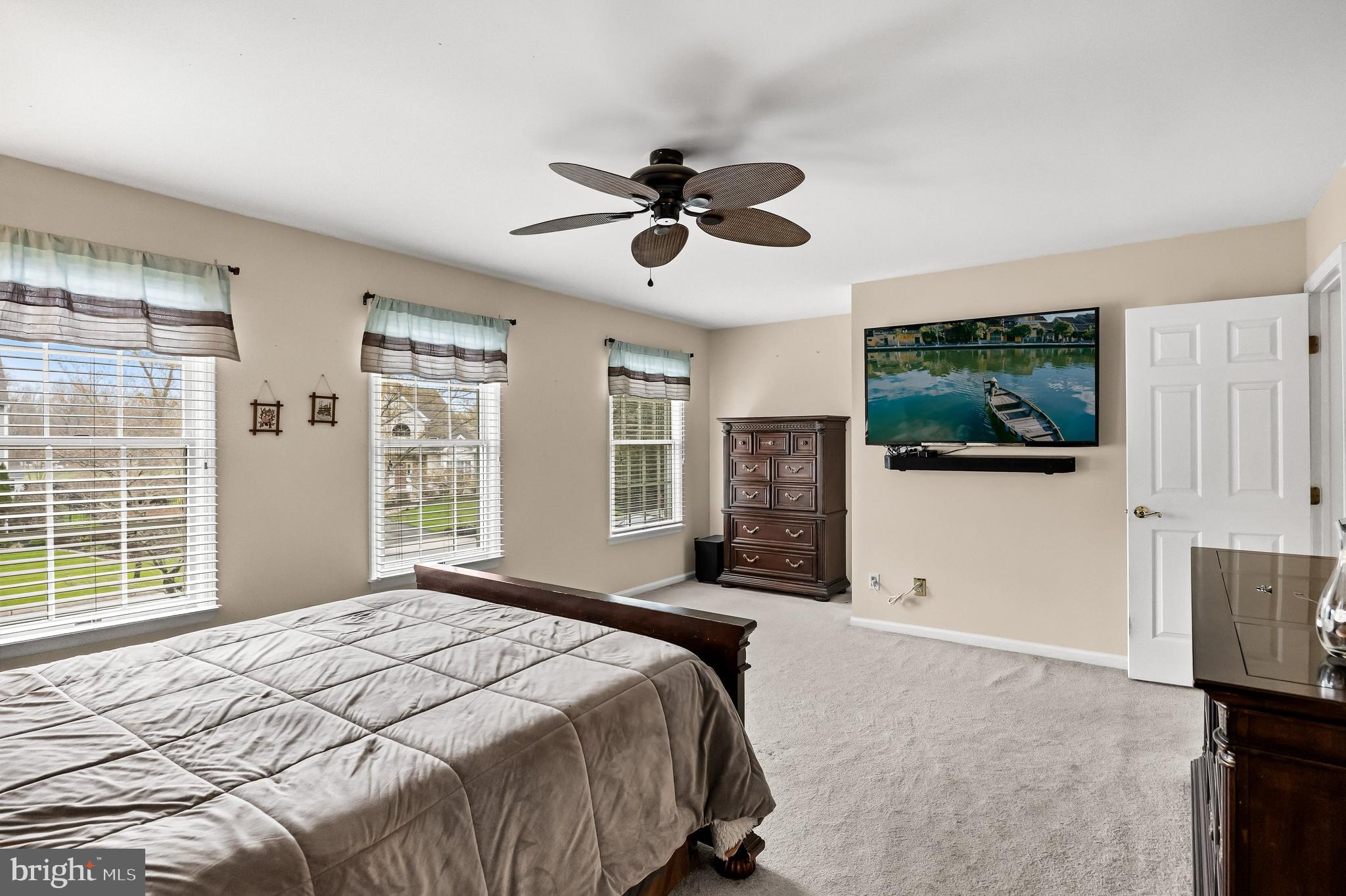 4 Mill Run Court Medford, NJ 08055 - Photo 20 of 53 a bedroom with a large bed a flat tv screen and a large window with the outer view