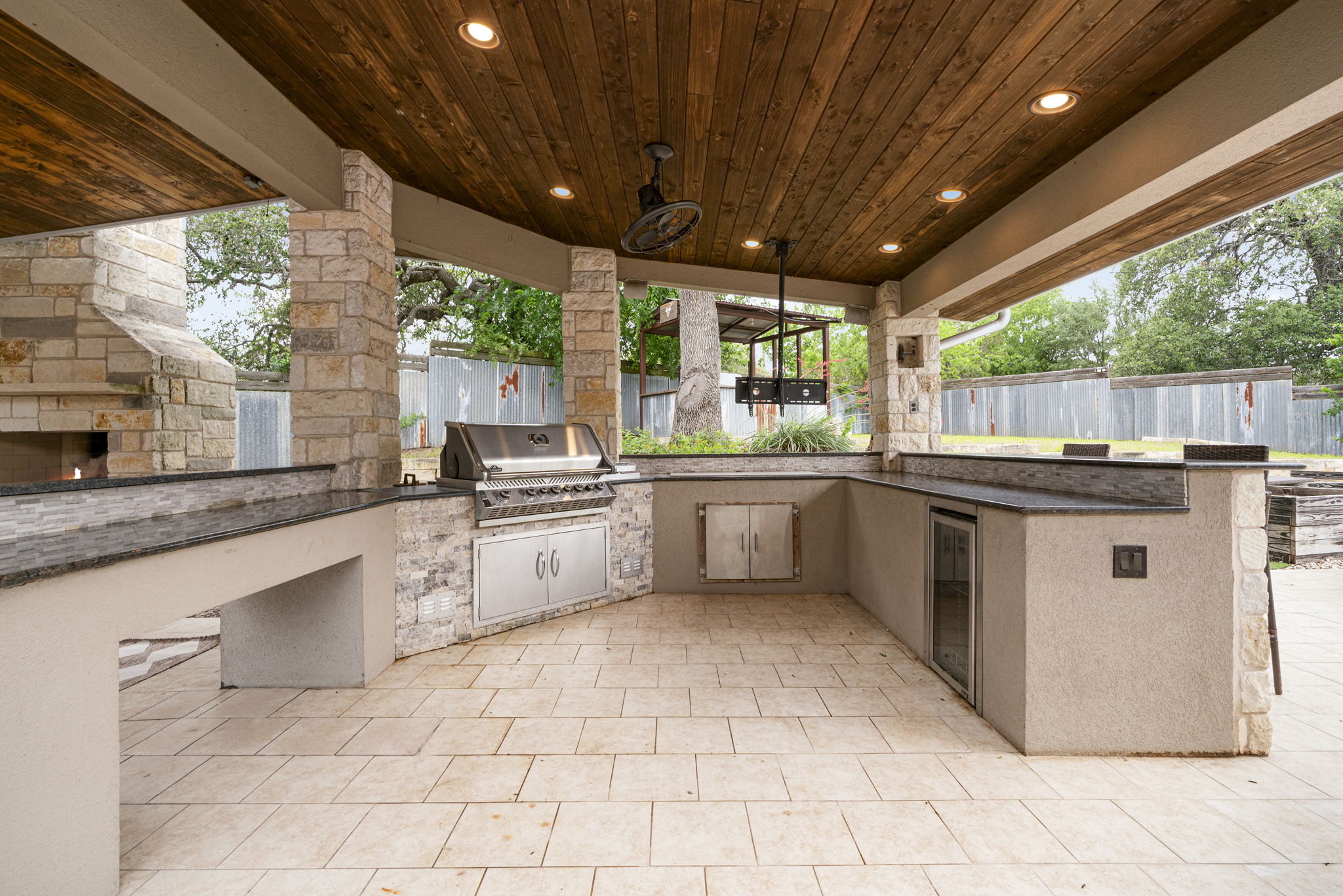 1129 Cedar Pass Road Driftwood, TX 78619 - Photo 30 of 40 This isn't just a grill; it’s a full outdoor kitchen. You have granite counters, a built-in stainless grill, a beverage fridge and even a dedicated TV mount so you never miss a game while you're flipping burgers.