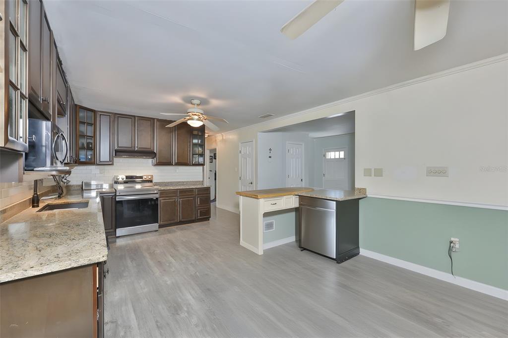 14451 Highland Road Wimauma, FL 33598 - Photo 52 of 80 a large kitchen with a stove top oven and sink