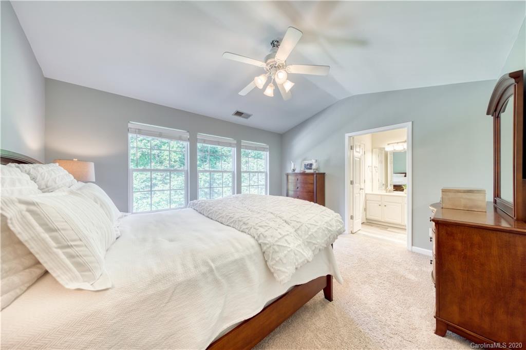 6921 Rothchild Drive Charlotte, NC 28270 - Photo 16 of 26 a bedroom with a large bed and a chandelier