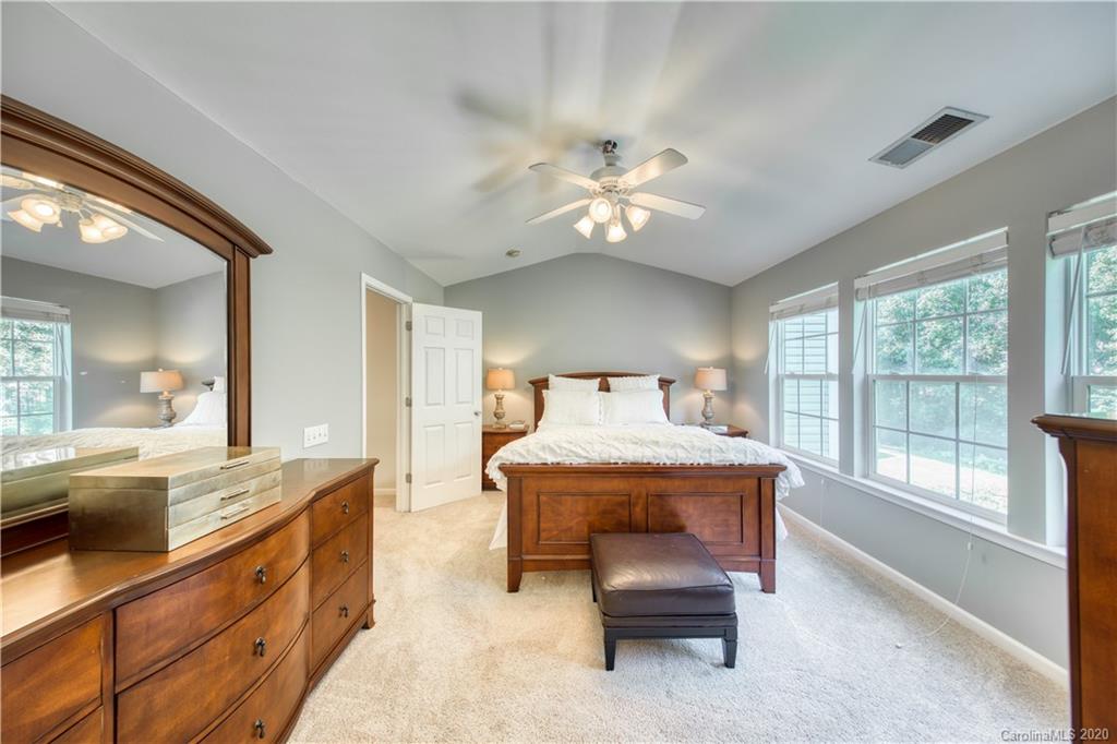 6921 Rothchild Drive Charlotte, NC 28270 - Photo 17 of 26 a spacious bedroom with a bed and a chandelier