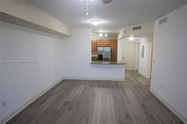 an empty room with wooden floor and mirror