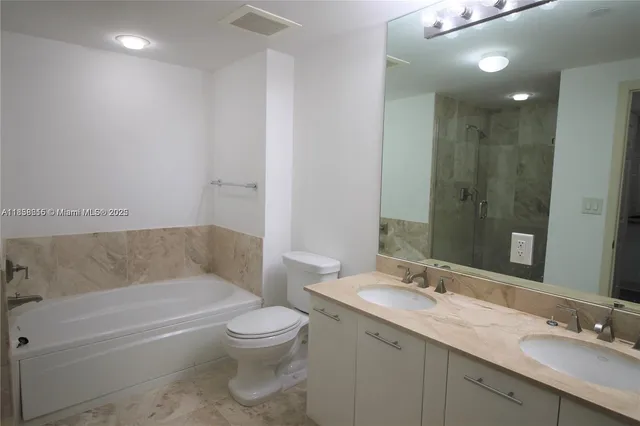 a bathroom with a granite countertop sink a toilet and bathtub