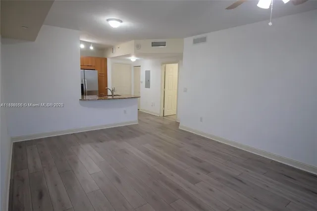 a view of an empty room with wooden floor
