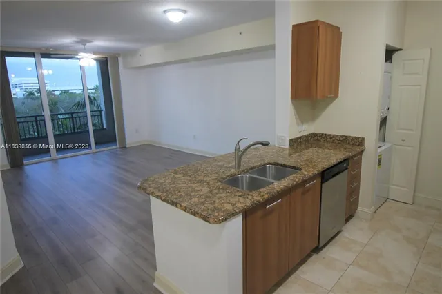 a kitchen with a granite countertop sink and cabinets
