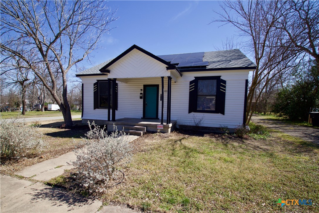 a front view of house with yard and trees
