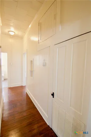 a view of a hallway with wooden floor