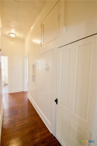 a view of a hallway with wooden floor
