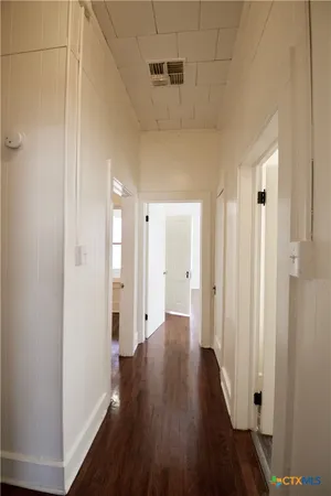 a view of a hallway with wooden floor