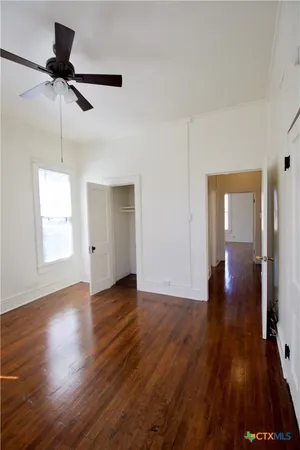 a view of empty room with wooden floor