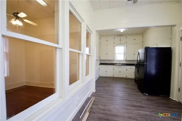 a kitchen with stainless steel appliances granite countertop a refrigerator a sink and a stove with wooden floor