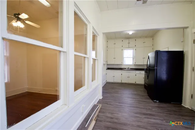 a kitchen with stainless steel appliances granite countertop a refrigerator a sink and a stove with wooden floor