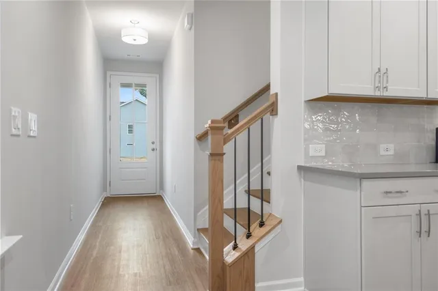 a view of an entryway with wooden floor and cabinets