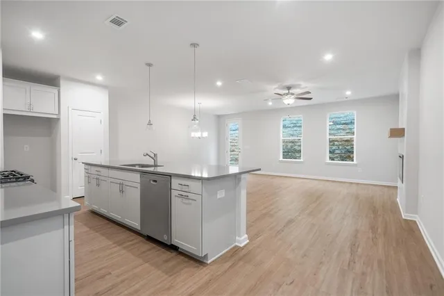 a large kitchen with granite countertop a large counter top and stainless steel appliances