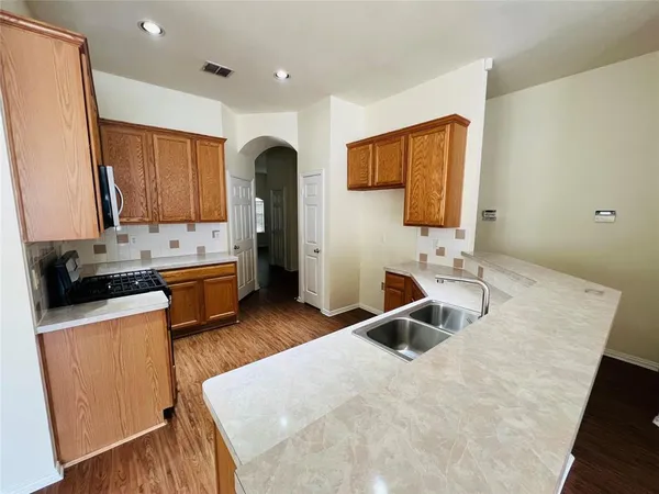 a kitchen with a sink appliances and cabinets