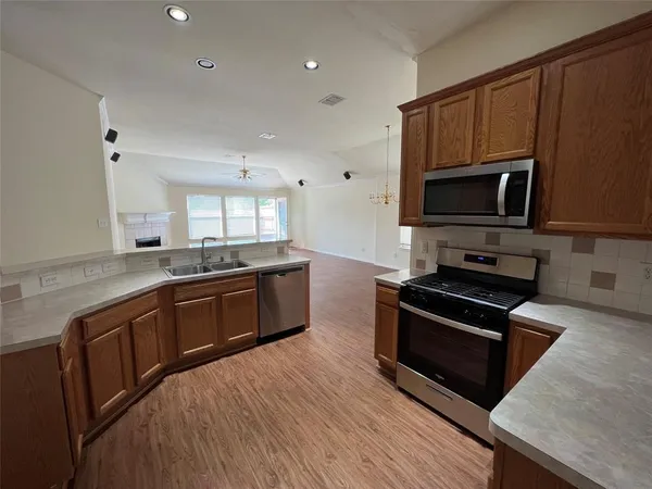 a kitchen with stainless steel appliances kitchen island granite countertop a stove a sink and a microwave