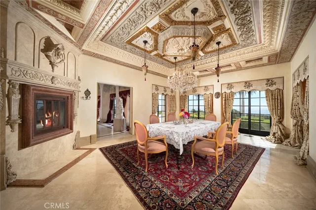 a dining room with wooden floor a chandelier a wooden table and chairs