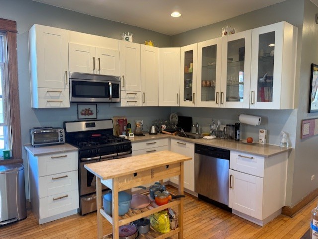 3330 West Evergreen Avenue Chicago, IL 60651 - Photo 11 of 16 a kitchen with a stove a sink and a microwave