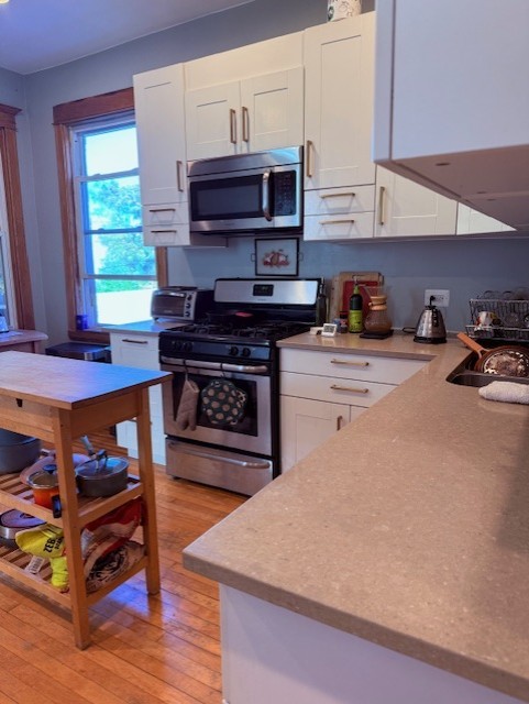3330 West Evergreen Avenue Chicago, IL 60651 - Photo 8 of 16 a kitchen with stainless steel appliances a stove a sink and a refrigerator