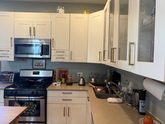 3330 West Evergreen Avenue Chicago, IL 60651 - Photo 10 of 16 a kitchen with stainless steel appliances a stove a sink and white cabinets