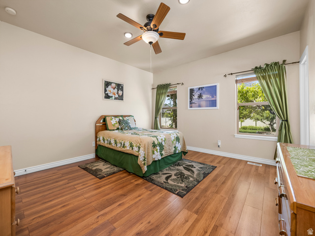 255 East 1200 North Mapleton, UT 84664 - Photo 12 of 37 Spacious room featuring wood-finish flooring, two windows with white trim, and a ceiling fan with integrated lighting