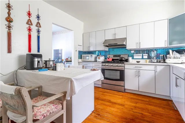 a kitchen with granite countertop a sink stainless steel appliances and white cabinets