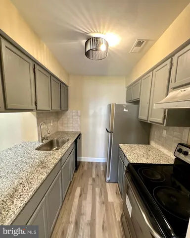 a kitchen with granite countertop stainless steel appliances and a counter space