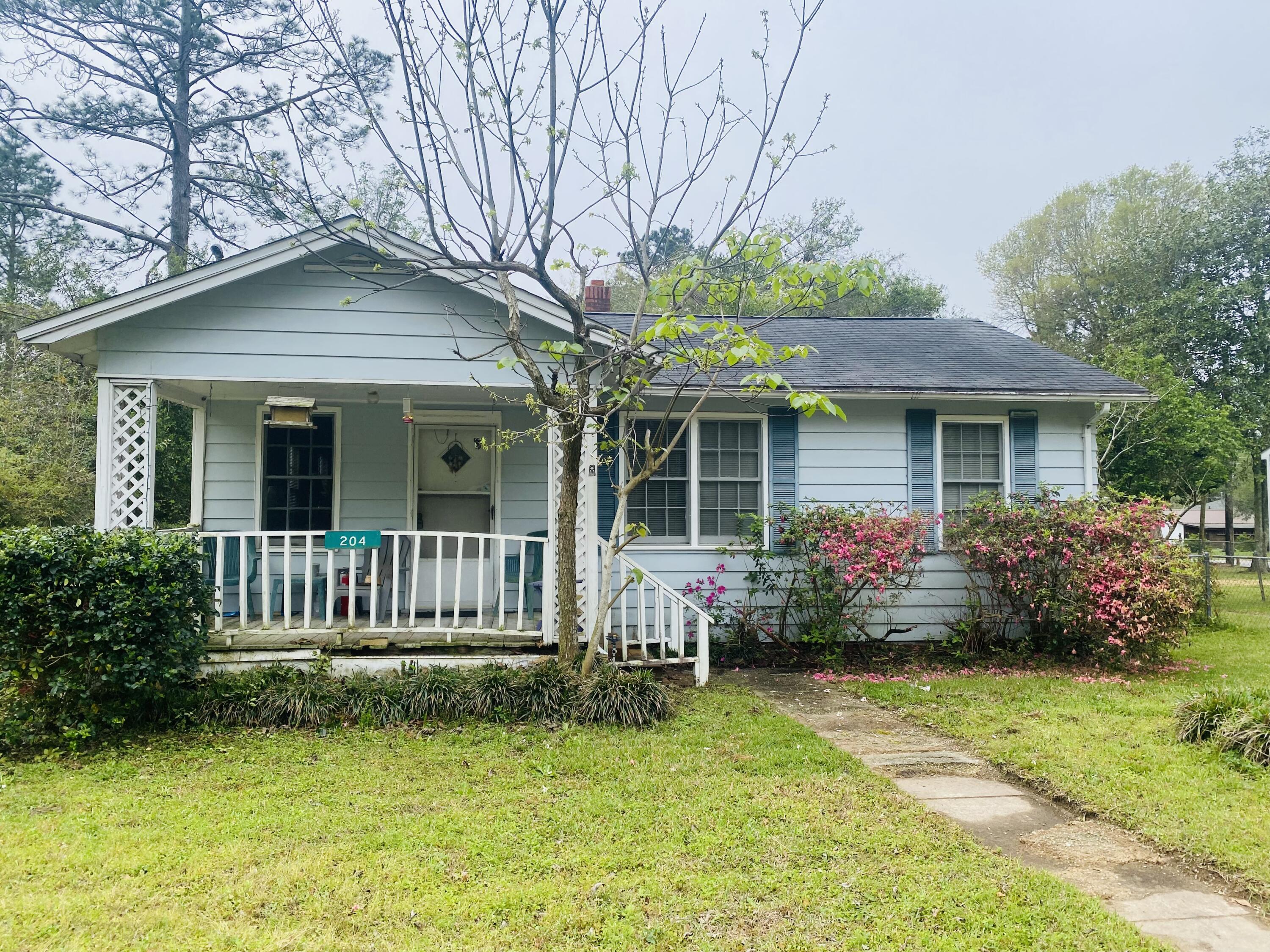 a front view of a house with a garden and porch