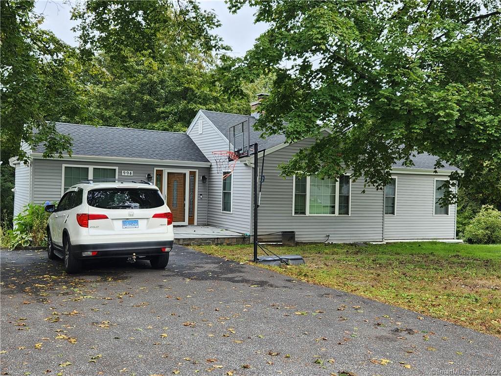 a view of house with backyard space and tree