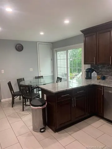 a kitchen with kitchen island granite countertop a sink stove and refrigerator