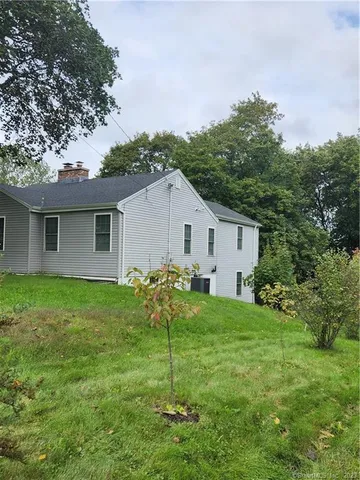 a view of a house with a backyard and a tree