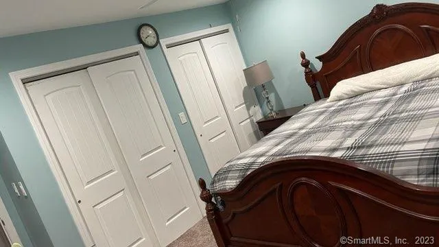 a bedroom with a bed and a painting on the wall