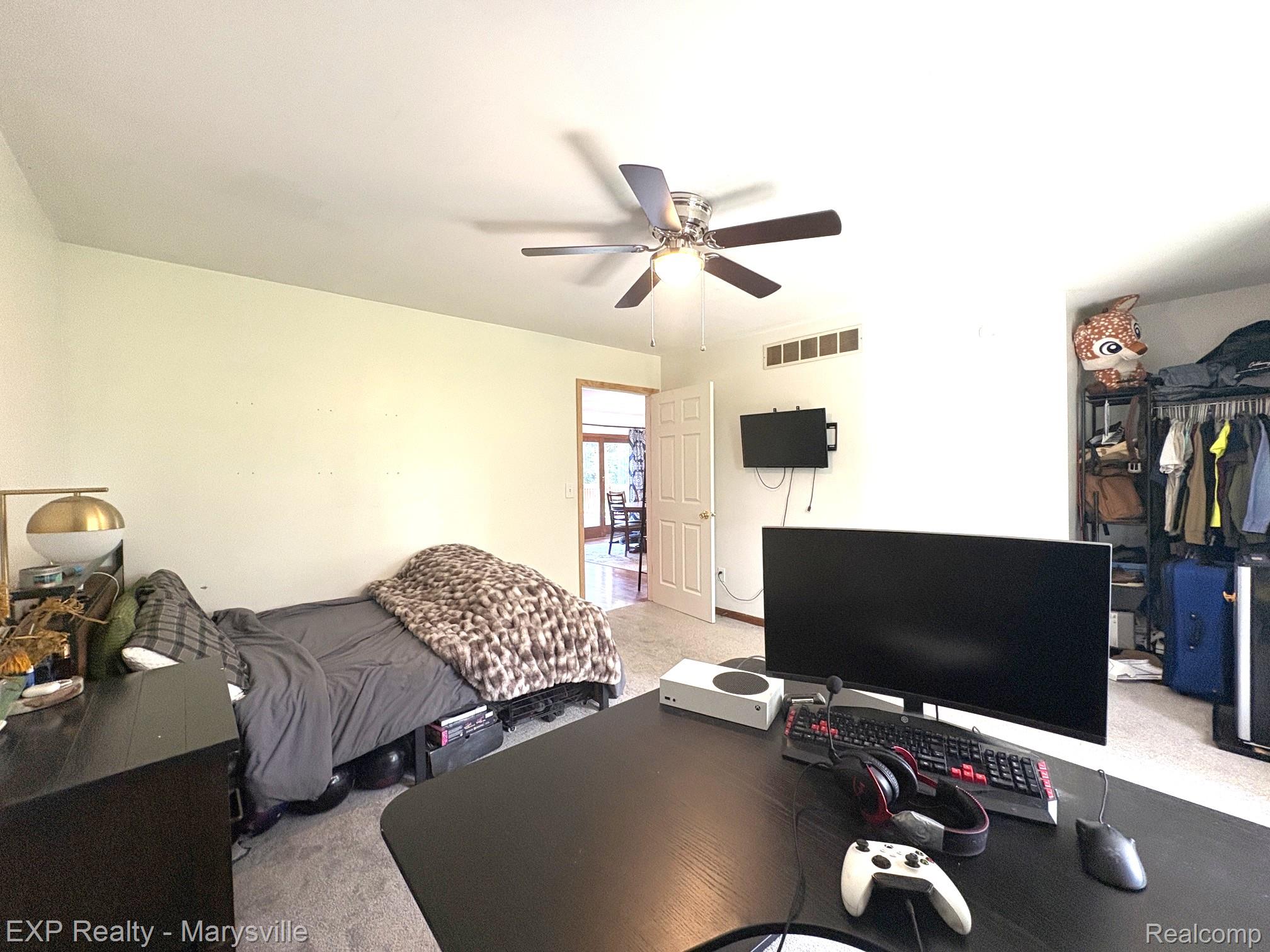 5538 Klettner Road St. Clair, MI 48079 - Photo 27 of 46 Carpeted room featuring a ceiling fan with integrated lighting, a wall-mounted television, and a white paneled door