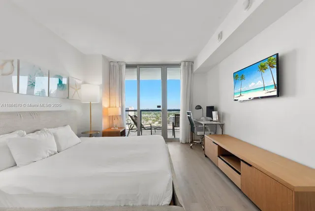 a bedroom with furniture and a large window