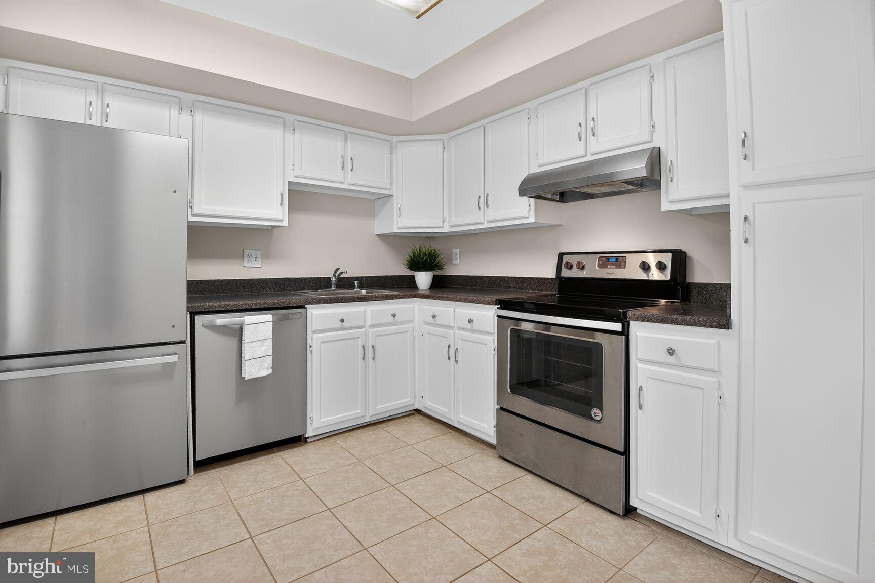 3423 Tendril Court Woodbridge, VA 22192 - Photo 8 of 20 a kitchen with white cabinets and white appliances