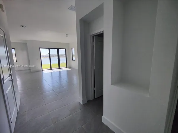 an empty room with wooden floor and glass door