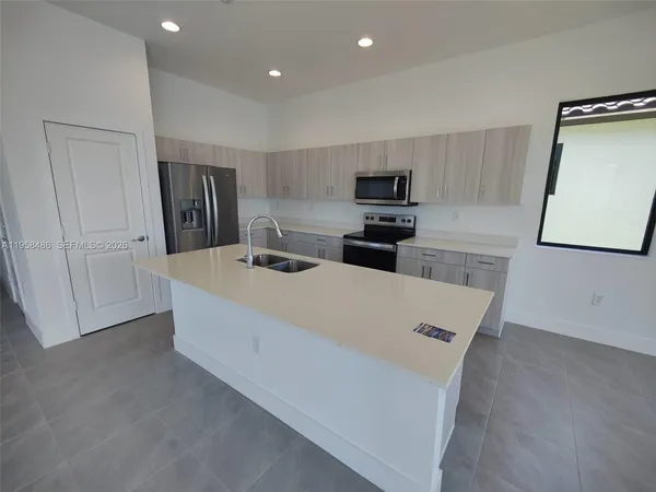 a kitchen with kitchen island white cabinets and refrigerator