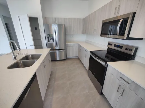 a kitchen that has a sink and a stove top oven