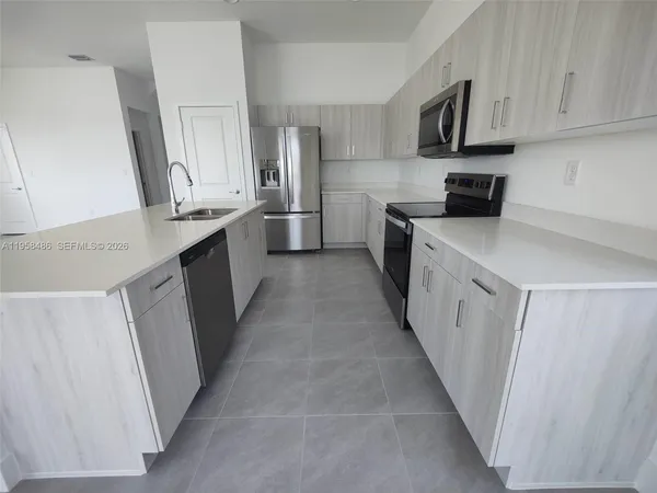 a kitchen with stainless steel appliances a sink stove refrigerator and cabinets
