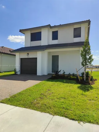 a front view of a house with a yard and garage