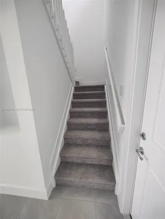 a view of staircase with white walls and railing