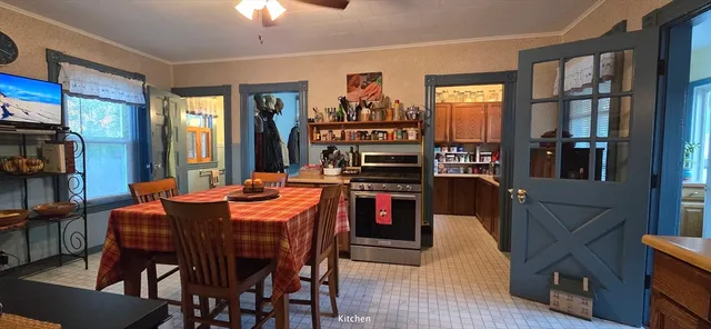 a kitchen with stainless steel appliances granite countertop a refrigerator a stove and a dining table with wooden floor