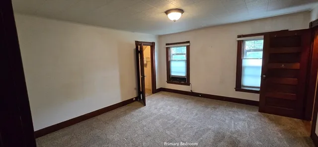 an empty room with closet and mirror