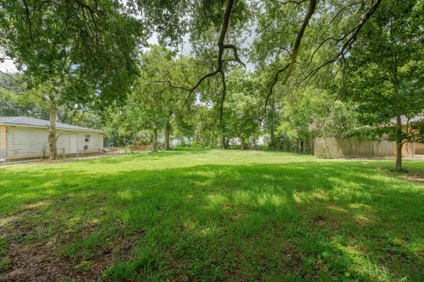 a view of a house with backyard and a tree
