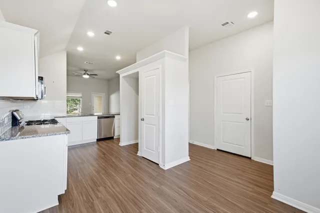 an empty room with wooden floor and windows