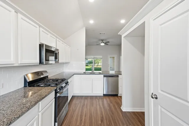 a view of a kitchen with wooden floor and a kitchen space